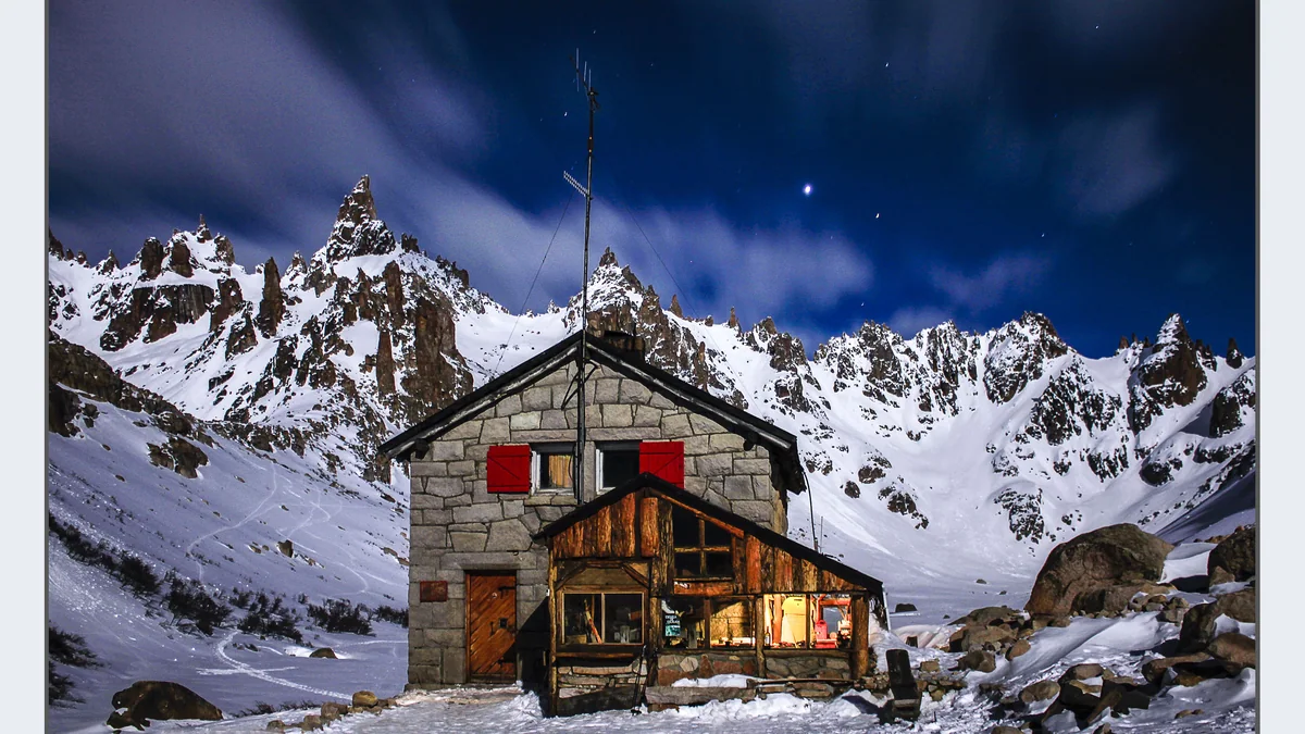 Refugio de montaña cubierto de nieve al pie de las agujas del Cerro Catedral
