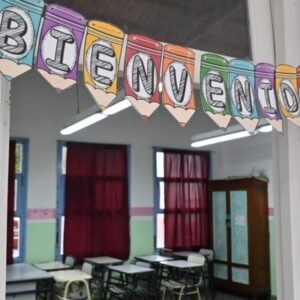 Un aula vacía con un cartel de bienvenida, en una escuela de Río Negro