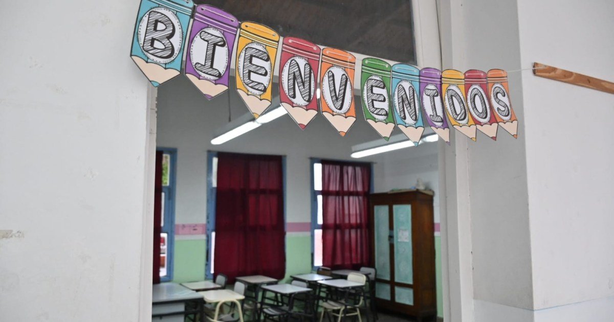 Un aula vacía con un cartel de bienvenida, en una escuela de Río Negro