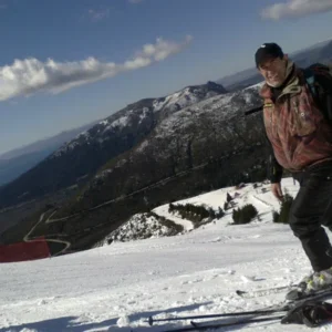 Un esquiador en una pista del Cerro Catedral, con el lago Nahuel Huapi de fondo
