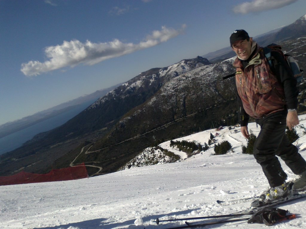 Un esquiador en una pista del Cerro Catedral, con el lago Nahuel Huapi de fondo