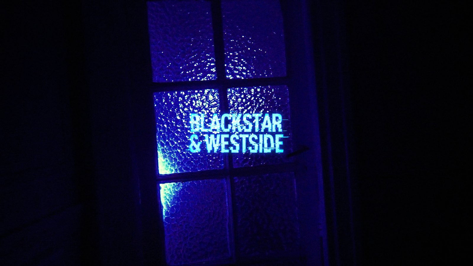 El título «Blackstar & Westside» proyectado en una ventana